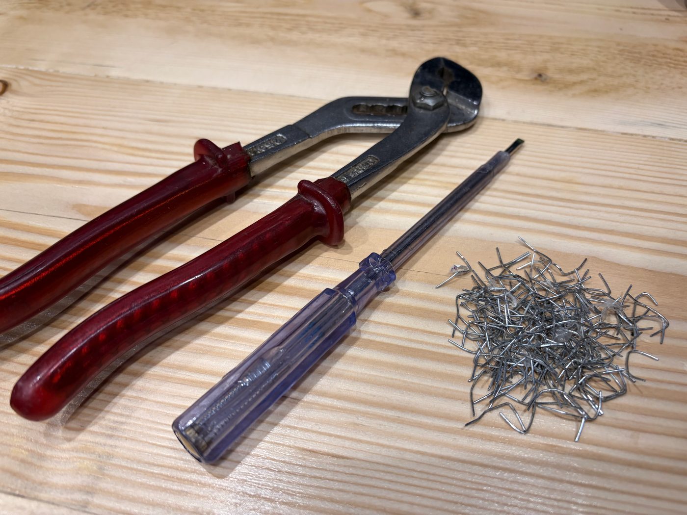 Staple remover, screwdriver and a pile of pulled staples