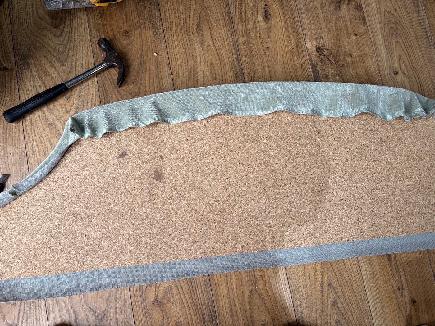 Recovering the board with fresh fabric, staple by staple